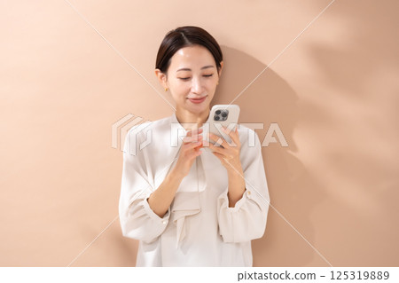 Woman beige back portrait smartphone 125319889