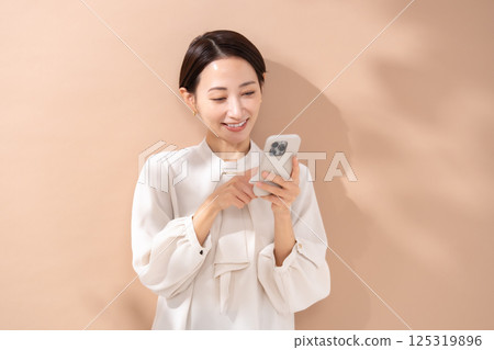 女人米色背面肖像智慧型手機 125319896