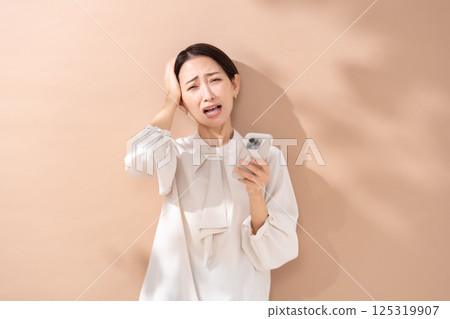Woman beige back portrait smartphone worries Woman beige back portrait smartphone worries 125319907