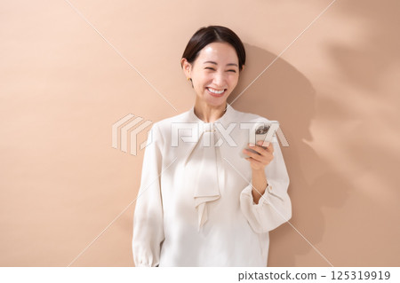 女人米色背面肖像智慧型手機 125319919