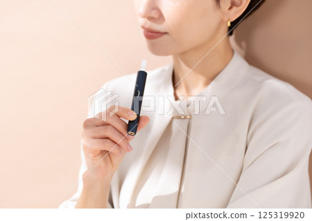 Woman smoking a heated cigarette 125319920