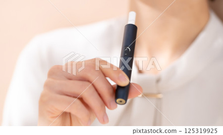Woman smoking a heated cigarette Woman smoking a heated cigarette 125319925