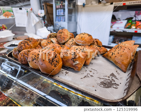 Uzbek baked samsa with black sesame on a tray in a traditional market in Prague Holesovice market, Czech republic Uzbek baked samsa with black sesame on a tray in a traditional market in Prague Holesovice market, Czech republic 125319996