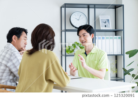 A care manager explaining a care plan to a middle-aged couple 125320091