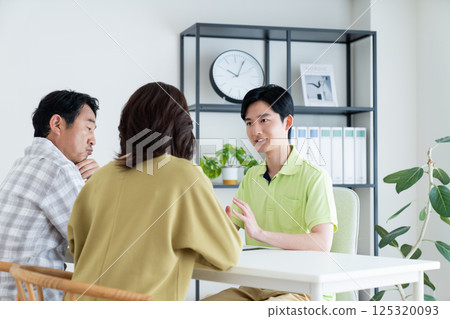 護理經理向一對中年夫婦講解護理計劃 護理經理向一對中年夫婦講解護理計劃 125320093