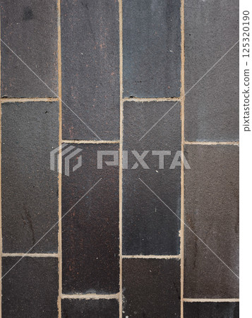 Modern dark gray brick wall forming a seamless textured background 125320190