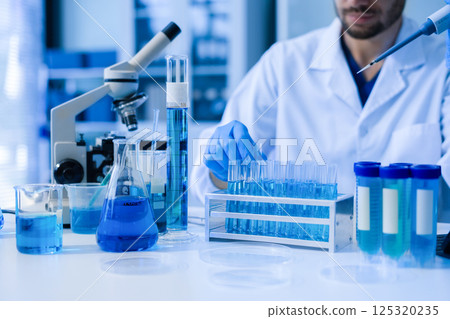 Chemist scientist holding test tube conducting experiment in laboratory with equipment. Chemist scientist holding test tube conducting experiment in laboratory with equipment. 125320235