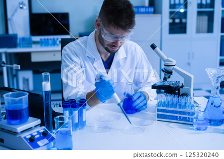 Chemist scientist holding test tube conducting experiment in laboratory with equipment. 125320240