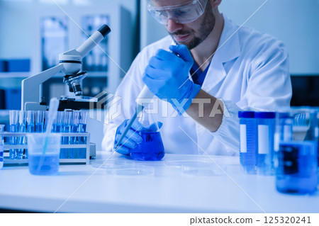 Chemist scientist holding test tube conducting experiment in laboratory with equipment. Chemist scientist holding test tube conducting experiment in laboratory with equipment. 125320241