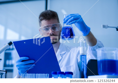 Chemist scientist holding test tube conducting experiment in laboratory with equipment. Chemist scientist holding test tube conducting experiment in laboratory with equipment. 125320244