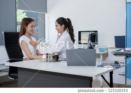 doctor measure heart rate by stethoscope on woman patient. Medical insurance service concept. 125320353