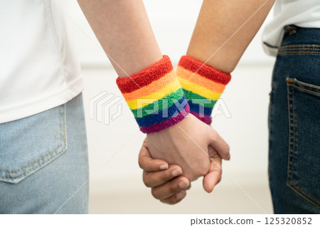 Asian LGBT couple woman holding hand wearing rainbow wristband. Asian LGBT couple woman holding hand wearing rainbow wristband. 125320852