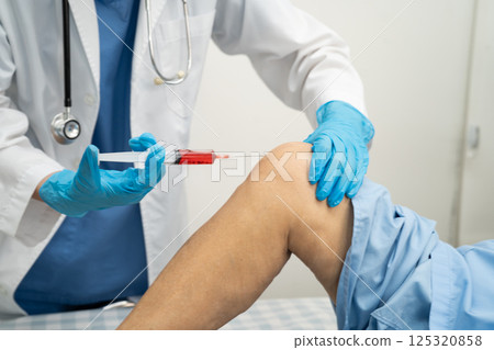 Asian doctor inject Hyaluronic acid platelet rich plasma into knee of senior woman. Asian doctor inject Hyaluronic acid platelet rich plasma into knee of senior woman. 125320858