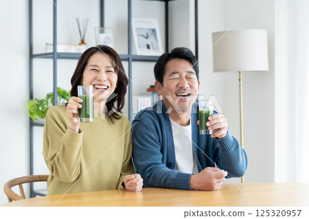 A middle-aged couple drinking green juice A middle-aged couple drinking green juice 125320957