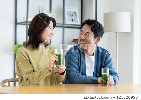 A middle-aged couple drinking green juice A middle-aged couple drinking green juice 125320958