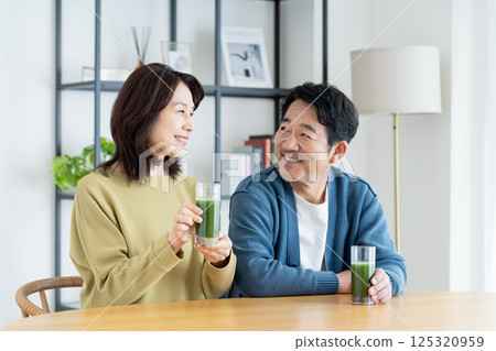 A middle-aged couple drinking green juice 125320959