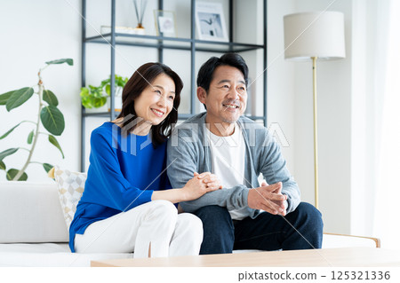 A middle-aged couple relaxing in the living room A middle-aged couple relaxing in the living room 125321336