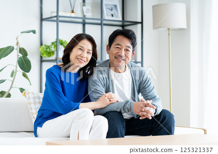 A middle-aged couple relaxing in the living room 125321337