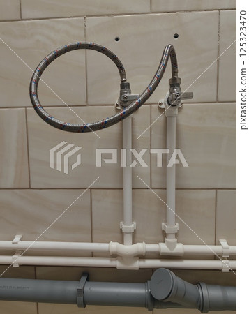 piping system installation view with water connections in residential setting. close-up. piping system installation view with water connections in residential setting. close-up. 125323470