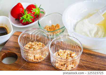 Making dessert: Laying biscuits in a glass dish 125323725