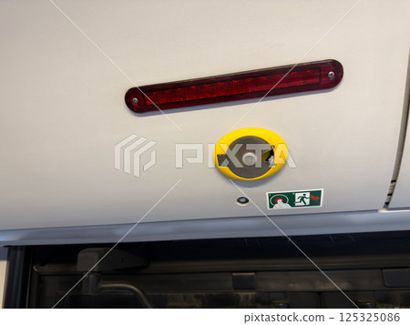 Close up of emergency mechanism with an icon based instruction system inside public transportation, highlighting functional and visual interface design 125325086