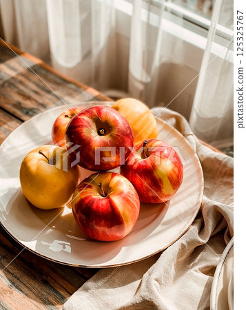 Red apples in drops of water on a white plate Red apples in drops of water on a white plate 125325767