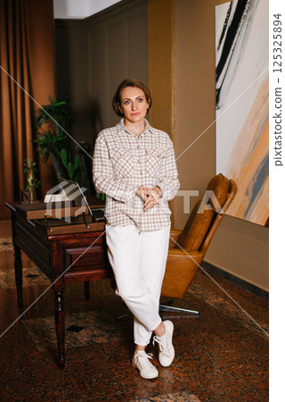 Thoughtful Woman Standing Near Desk In Office 125325894
