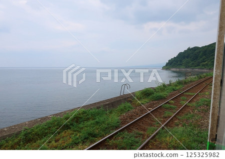JR Hokkaido, Hakodate Main Line, local train window view from Mori Station to Yakumo Station (cloudy sky in summer 2023) JR Hokkaido, Hakodate Main Line, local train window view from Mori Station to Yakumo Station (cloudy sky in summer 2023) 125325982
