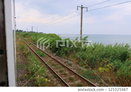 JR Hokkaido, Hakodate Main Line, local train window view from Mori Station to Yakumo Station (cloudy sky in summer 2023) JR Hokkaido, Hakodate Main Line, local train window view from Mori Station to Yakumo Station (cloudy sky in summer 2023) 125325987