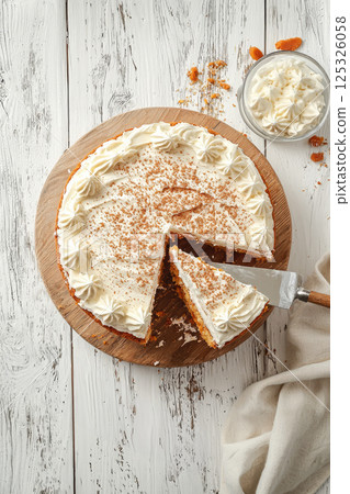 Homemade carrot cake with cheese cream topping on white wooden table. Top view 125326058