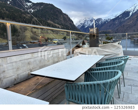 kaprun, modern rooftop bar without people. snowy mountains background, spring and changing season. relax atmosphere kaprun, modern rooftop bar without people. snowy mountains background, spring and changing season. relax atmosphere 125326983