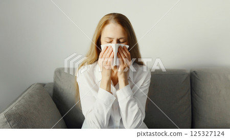 Sick exhausted young woman sneezing blow nose using tissue, unhealthy suffering girl feels unwell Sick exhausted young woman sneezing blow nose using tissue, unhealthy suffering girl feels unwell 125327124