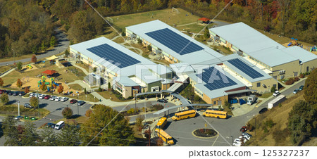 Roof of american school building covered with photovoltaic solar panels for production of electric energy. Renewable energy concept 125327237