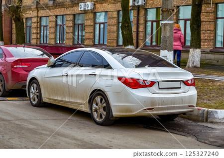 car parked in the street, side view on brick building background car parked in the street, side view on brick building background 125327240