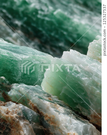 Green jade mineral close-up with natural crystal texture and layers. Studio lighting photography. Gemstone and geology concept. Design for print, poster, banner, wallpaper. Macro shot Green jade mineral close-up with natural crystal texture and layers. Studio lighting photography. Gemstone and geology concept. Design for print, poster, banner, wallpaper. Macro shot 125327537