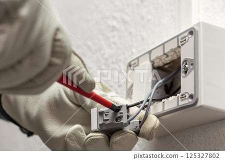 Electrician at work on a residential electrical system. Electricity. 125327802