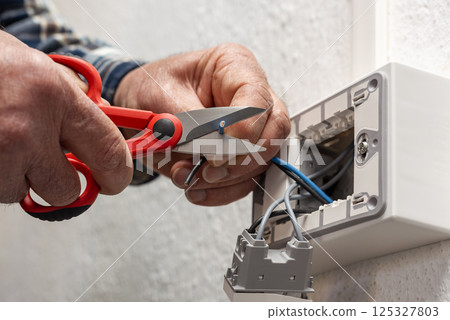 Electrician at work on a residential electrical system. Electricity. 125327803