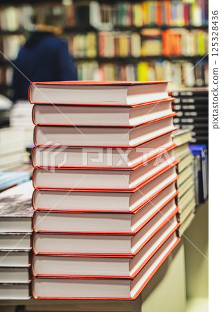 Stack of red hardcover books neatly arranged on bookstore display. Books represent knowledge, reading, literature and modern publishing Stack of red hardcover books neatly arranged on bookstore display. Books represent knowledge, reading, literature and modern publishing 125328436