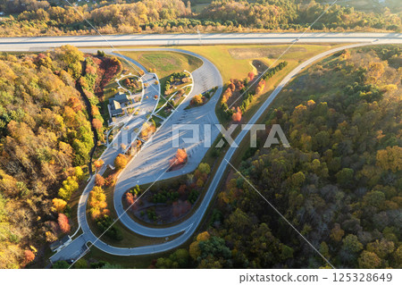 Rest area between golden fall forest near busy multilane American freeway with fast moving cars and trucks. Recreational resting place during interstate traveling thru USA mountains 125328649