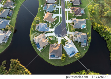 Residential homes at sunset in suburban sprawl development in North Port, Florida. Low-density private houses in rural suburbs. Housing market in the USA Residential homes at sunset in suburban sprawl development in North Port, Florida. Low-density private houses in rural suburbs. Housing market in the USA 125328668