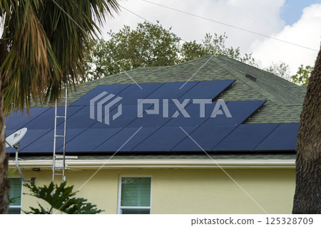 Private home roof covered with solar photovoltaic panels for generating of clean ecological electric energy in suburban rural town area. Concept of autonomous house 125328709