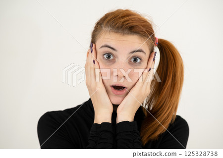 Portrait of serious young woman holding her hands to face thinking concentrated about something. Portrait of serious young woman holding her hands to face thinking concentrated about something. 125328738