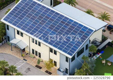 Photovoltaic panels for producing clean ecological electric energy. Florida office building with solar roof. Renewable electricity with zero emission concept Photovoltaic panels for producing clean ecological electric energy. Florida office building with solar roof. Renewable electricity with zero emission concept 125328790