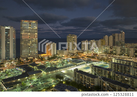 Night urban landscape of downtown district in Sunny Isles Beach city in Florida, USA. Skyline with brightly illuminated high skyscraper buildings in modern american megapolis 125328811