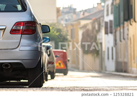 Modern cars parked on city street side in residential discrict. Shiny vehicles parked by the curb. Urban transportation infrastructure concept. 125328821