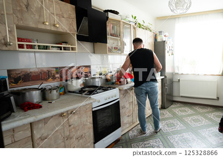 Cooking adventure in a cozy kitchen with warm light and personal touches showcasing daily life and culinary creativity 125328866