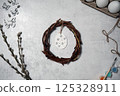 the easter wreath from branches vines with thread on grey background with copyspace. decoration with eggs 125328911