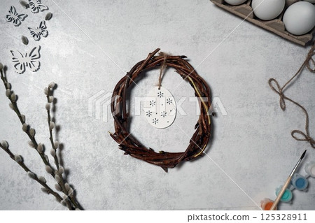 the easter wreath from branches vines with thread on grey background with copyspace. decoration with eggs 125328911