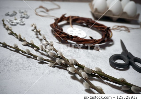 the easter wreath from branches vines with thread on grey background with copyspace. DIY decoration with eggs the easter wreath from branches vines with thread on grey background with copyspace. DIY decoration with eggs 125328912
