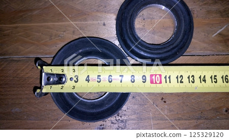 Measurement of pump seal collar on wooden surface with tape measure 125329120